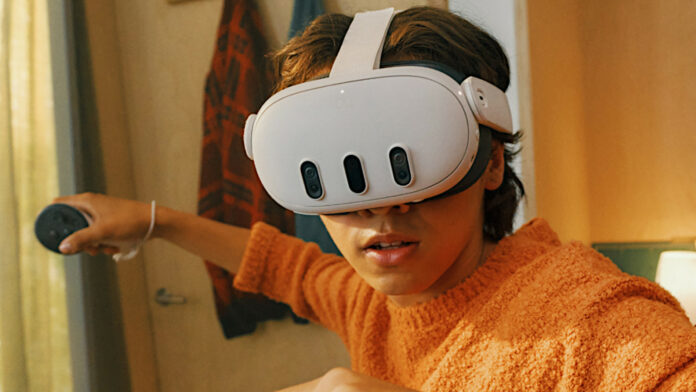 A person wearing a Meta Quest 3 VR headset, sporting an orange jumper and wielding a controller in their hand