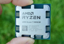 An AMD Ryzen 7 7800X3D held over green grass