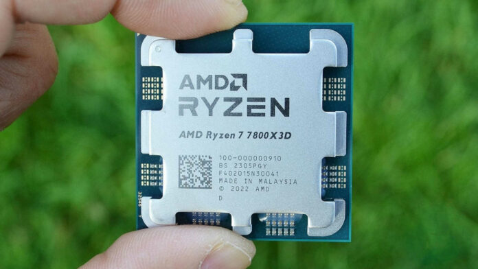 An AMD Ryzen 7 7800X3D held over green grass