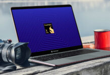 Snapdragon X Elite laptop, on a wooden bench, with a camera (left) and coffee cup (right) next to it