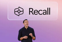 A Microsoft employee stands in front of a screen displaying the Windows Recall logo above their head