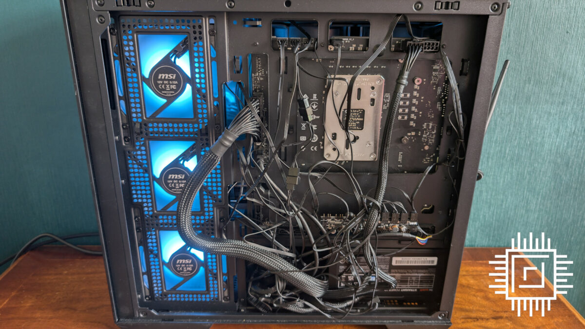 The back of a build using MSI B650M Project Zero, featuring a mess of wires in the back panel of a case