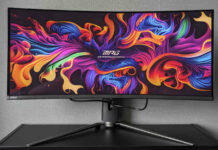 MSI MPG 341CQPX QD-OLED standing atop a black surface, against a grey background, its display brightly lit by ribbons of various colours