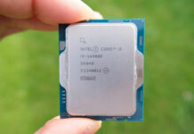 Intel Core i9 14900K processor, held between two fingers, against a blurred green background