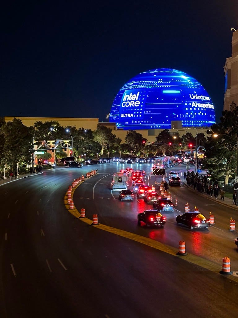 A landscape shot, in which Las Vegas Sphere is visible (top right) showing an Intel Core Ultra logo, with traffic flowing beneath it