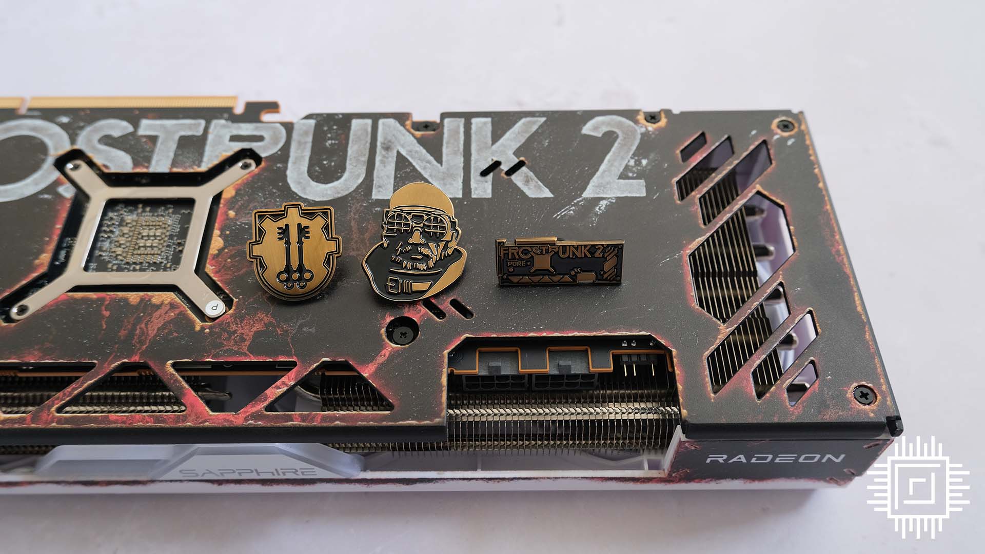 A picture of the Sapphire Radeon RX 7700 XT Frostpunk 2 pin badges.