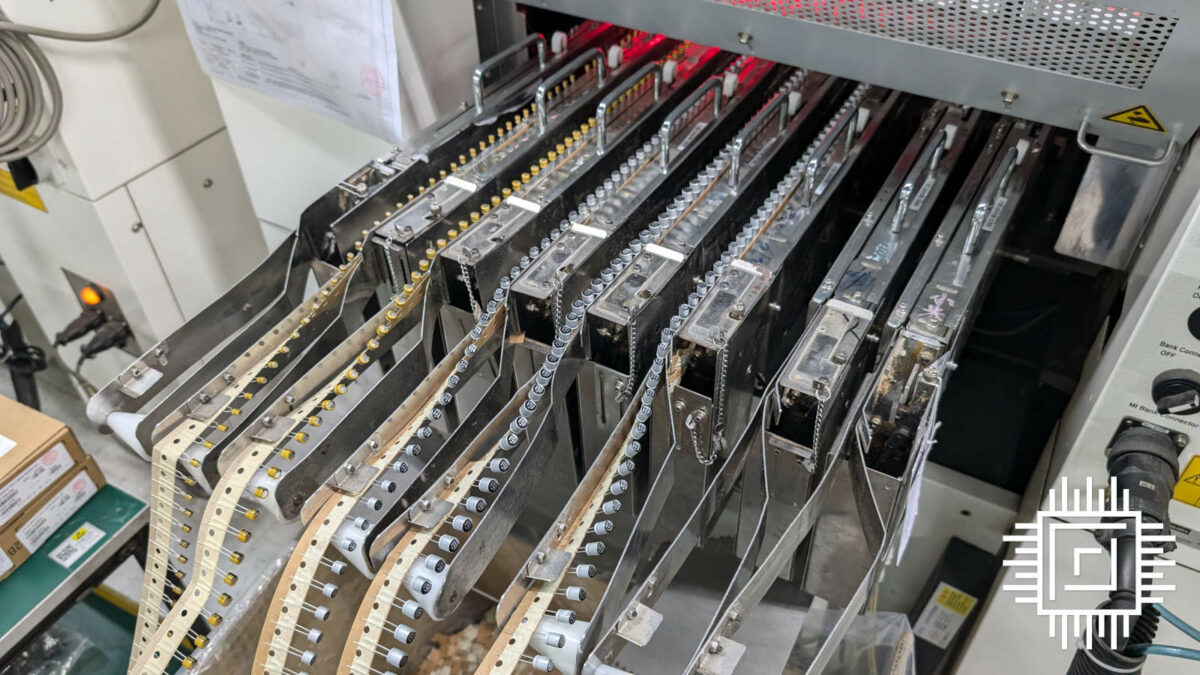 Several rows of resistors are fed into a machine.