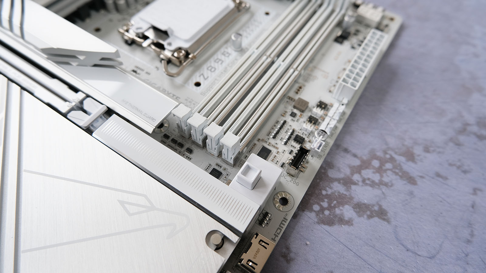 A picture of the Gigabyte Z890 Aorus Pro Ice motherboard with a close-up on the GPU latch.