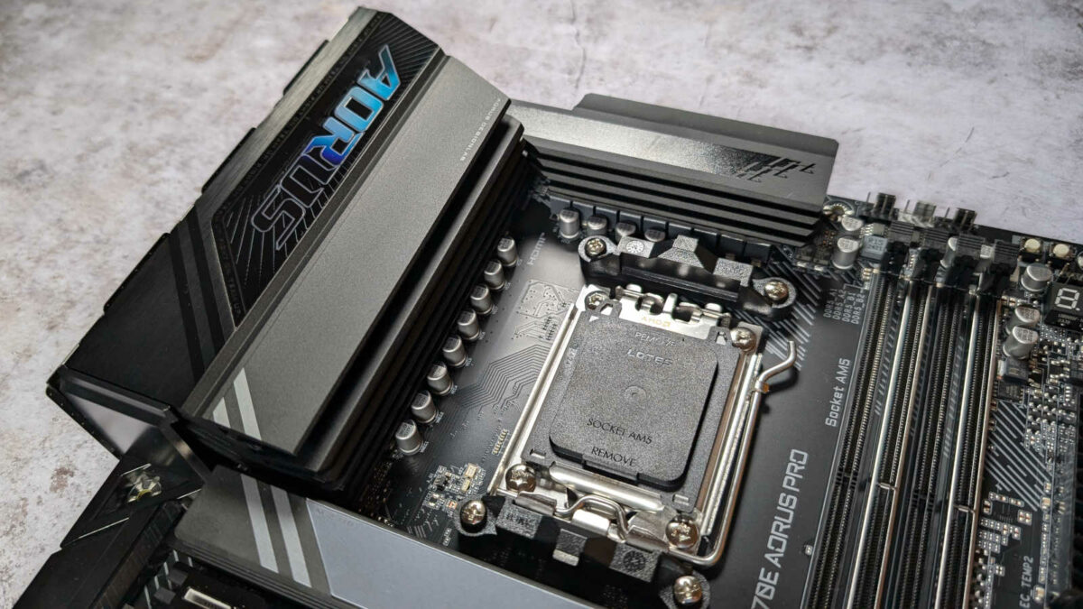 VRM heatsinks of X870E Aorus Pro motherboard, atop a wooden surface.