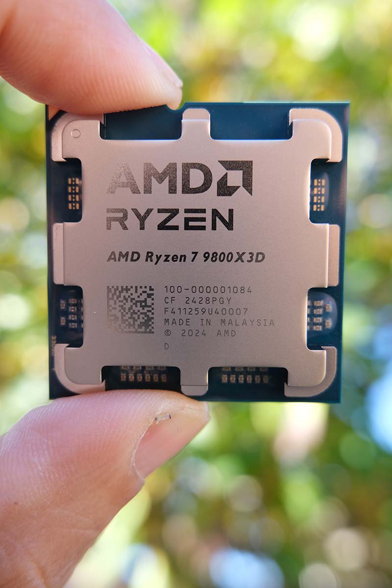 A picture of the AMD Ryzen 7 9800X3D CPU in hand.