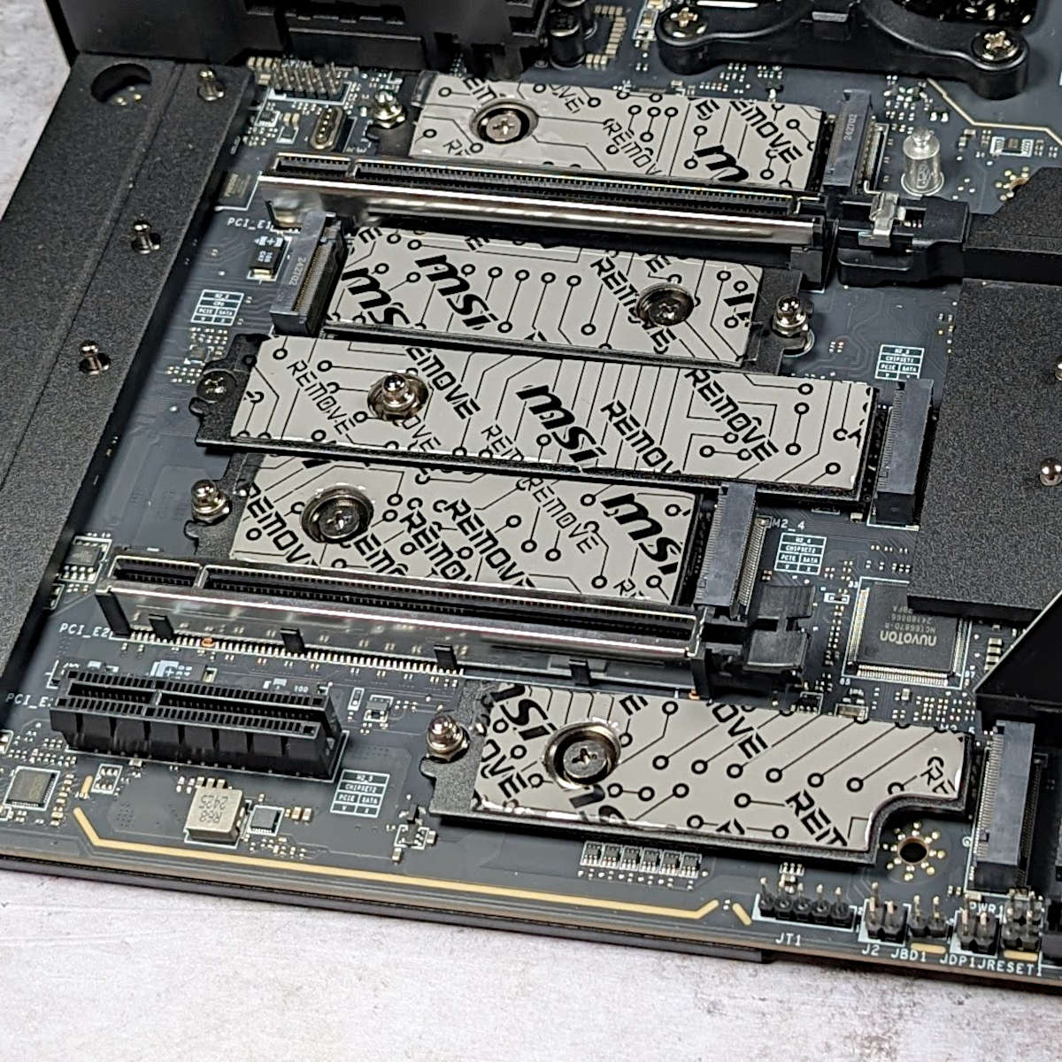 A series of thermal pads, covering M.2 slots on MEG X870E Godlike.