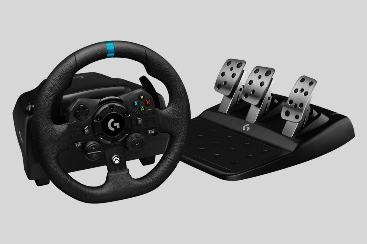 Logitech G923 steering wheel next to pedals.