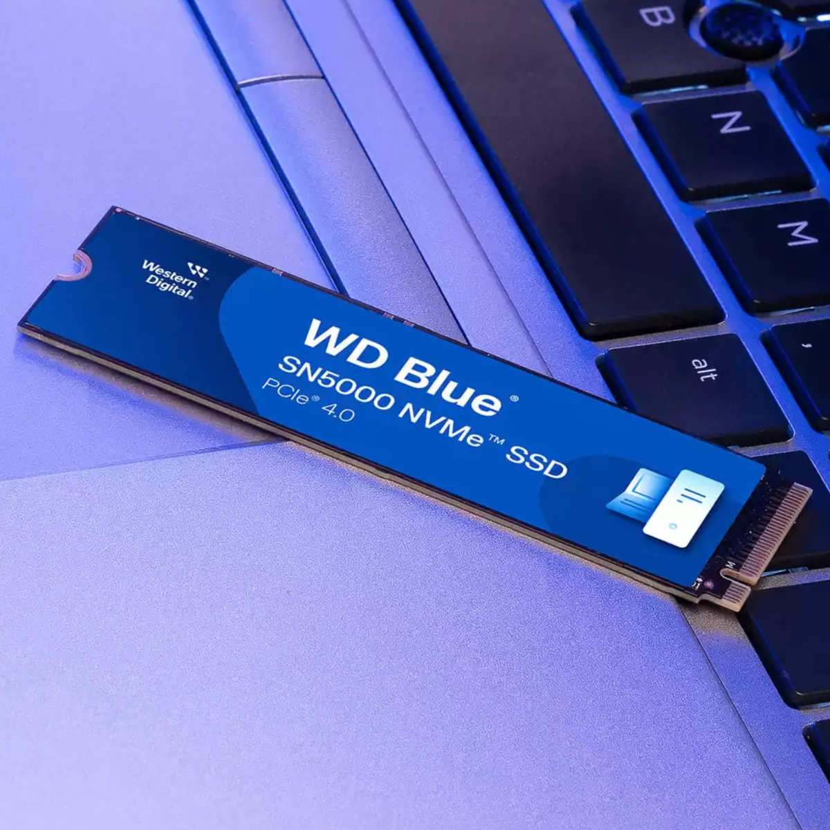 WD Blue SN5000 SSD lying on a laptop keyboard.