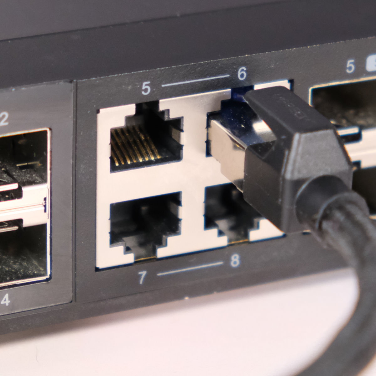 Close up of QNAP 10Gb/s switch with Ethernet cable plugged in.