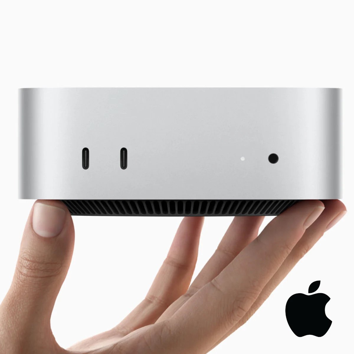 Apple Mac Mini resting on the tips of someone's fingers.