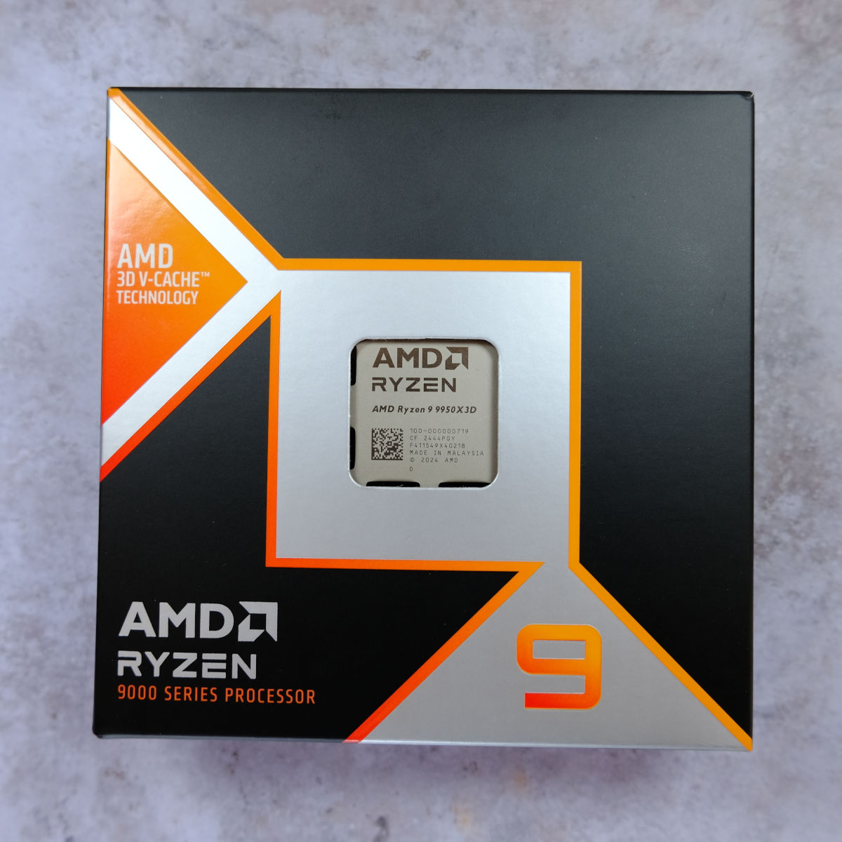 AMD Ryzen 9 9950X3D retail packaging, against a pearlescent background.