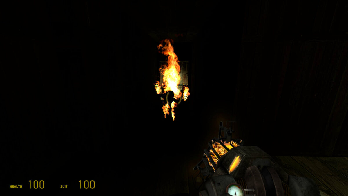 A headcrab zombie aflame walks down a dark corridor, its fire providing no dynamic lighting, in Half-Life 2.