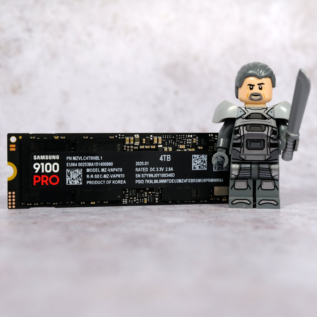 Samsung 9100 Pro SSD standing upright next to a LEGO figurine of Gurney Halleck.