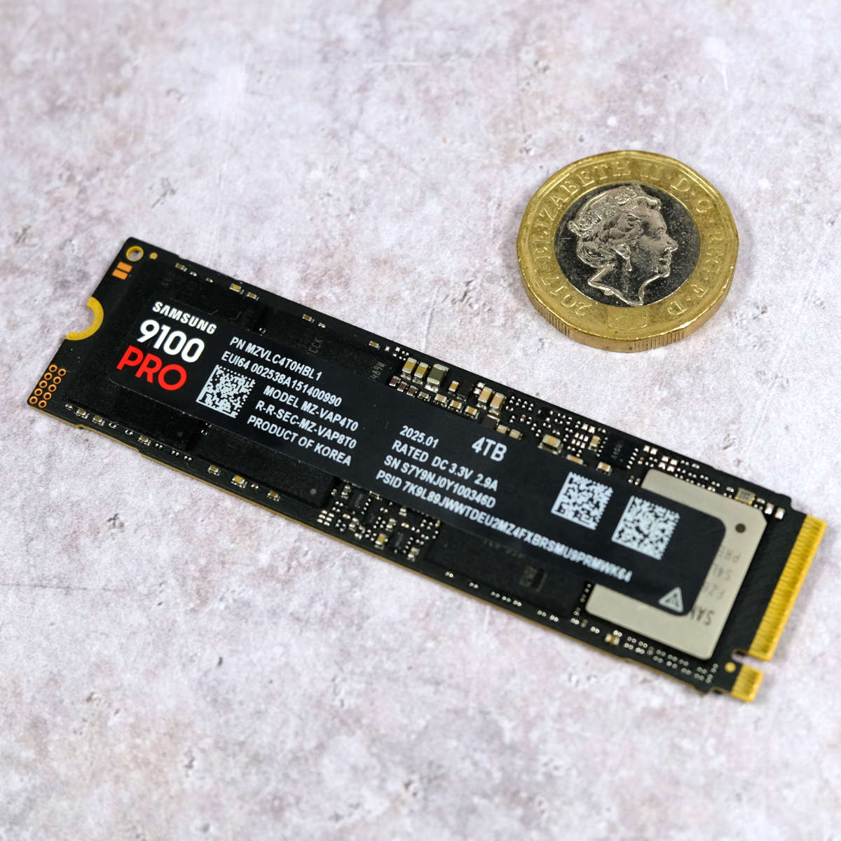 Samsung 9100 Pro SSD (left) placed below a £1 coin (right).